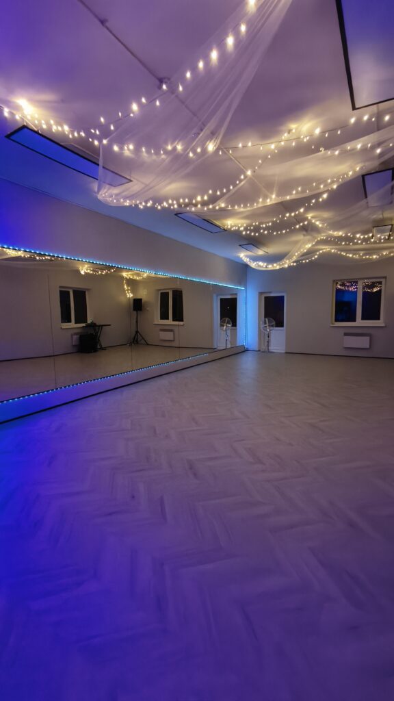Spacious, modern studio in Tallinn with large wall mirrors, soft ambient lighting, and elegant string lights across the ceiling — ideal for dance, yoga, fitness classes, or private events.